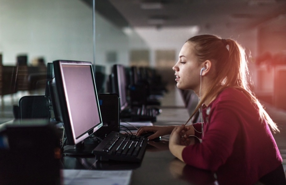 High Heel Hustle — young woman focused at her workstation in a computer lab.
